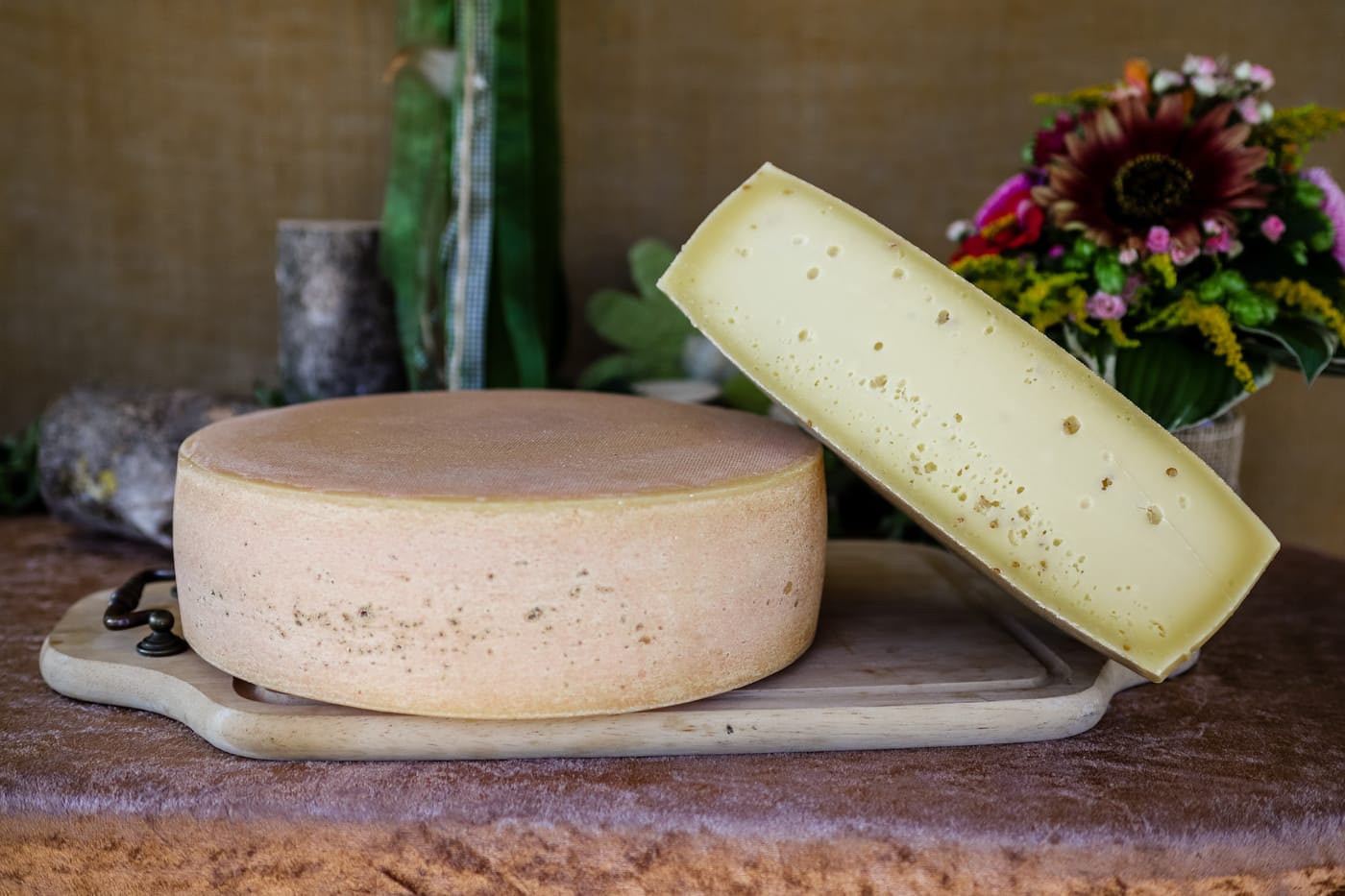 Ein Laib Käse aus der Milch der hofeigenen Kühe, daneben ein angeschnittenes Stück